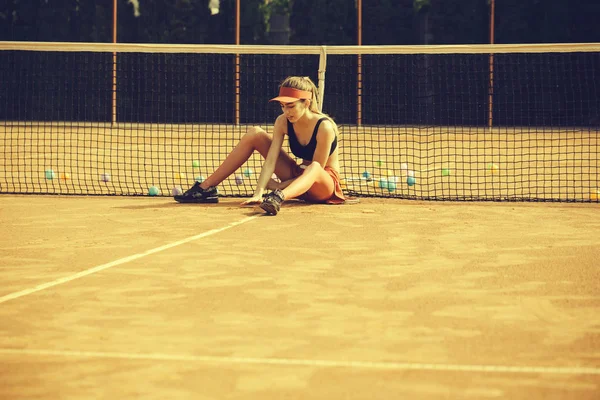 Szkolenia na tenis. Pozowanie modnej kobiety. Kobieta siedząca i zrelaksować się na kort tenisowy w WPR — Zdjęcie stockowe