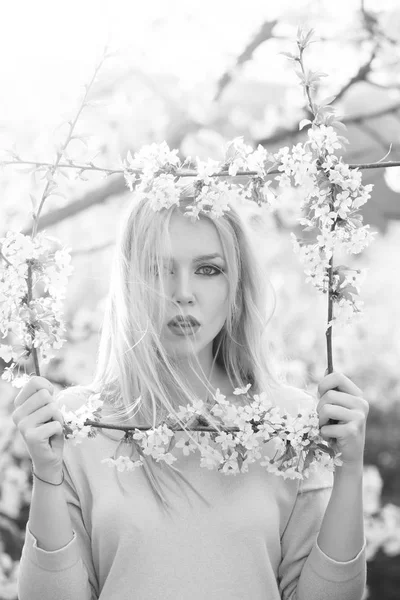 Maquillaje de primavera. Mujer de moda posando. mujer sosteniendo el marco de blanco, flores en flor — Foto de Stock