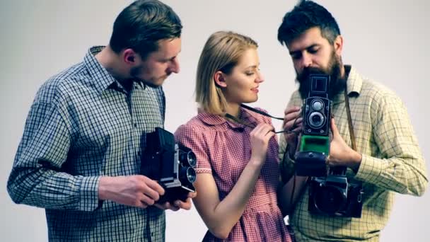Fotografen, die Retro-Kameras studieren und ihre Ideen miteinander teilen. Retro-Shooting-Konzept.