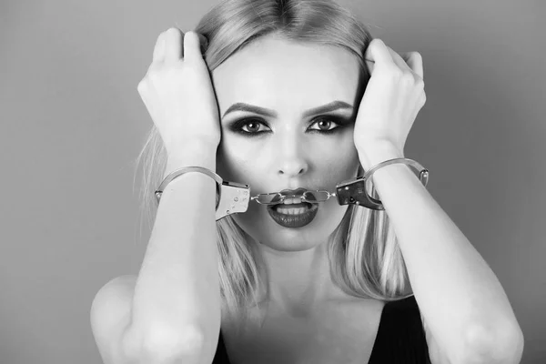 Gewalt gegen Frauen. Mädchen mit Handschellen, sexy blonde Frau mit roten Lippen — Stockfoto