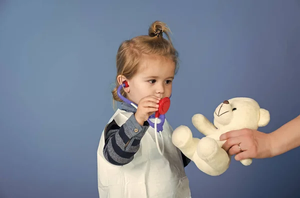 Barn spelar läkare. Barn spela veterinär med Nalle i mödrar hand — Stockfoto