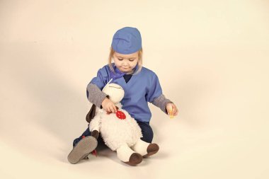 Veteriner Tıp gelecek. Doktor veteriner oyuncak hayvan ile oynarken üniforma içinde küçük çocuk