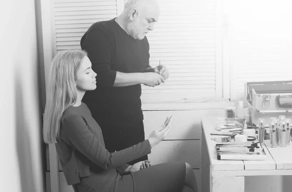 makeup school. Visagiste man preparing brush for woman face makeup