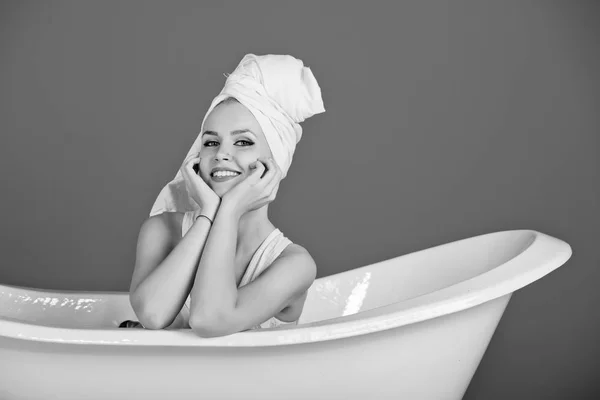 Womens leisure. happy sexy woman with towel turban sitting in white bathtub — Stock Photo, Image