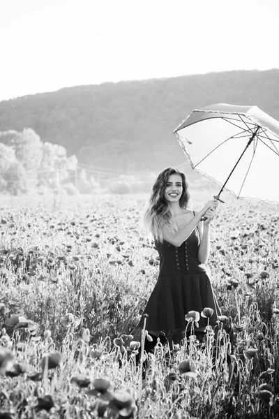 Descanso de verano. niña en el campo de semillas de amapola con paraguas — Foto de Stock