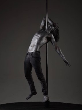 Güçlü dansçı egzersiz kutup. Özgürlük. Pilon üzerinde dans gümüş gövde sanat kaslı adam. Pole dans spor. Metal yüzey ile seksi maço. Atletik adam olun akrobatik öğeleri pilon üzerinde.