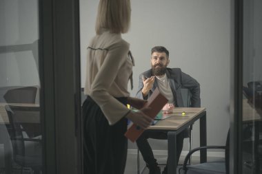 İş adamı ve iş işleminde işkadını. Sakallı erkek ve kadın iş görüşmem var. Patron Sekreter ofiste konuşun. İletişim ve iş arkadaşları ile işbirliği. Yoğun bir gün ofiste