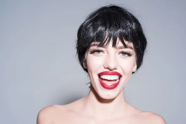 Jovem alegre com sorriso perfeito e lábios vermelhos isolados em fundo cinza. Menina em peruca preta fantasia rindo em estúdio, conceito de felicidade — Fotografia de Stock