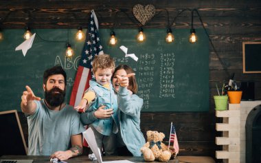 Resepsiyon ile kağıt uçak yapma evlat, Amerikan ailesi. Evde eğitim kavramı. Anne oğlu Amerikan gelenekleri oynarken öğretim. ABD bayrağı ile sınıf, arka plan kara tahta ebeveynler çocuk