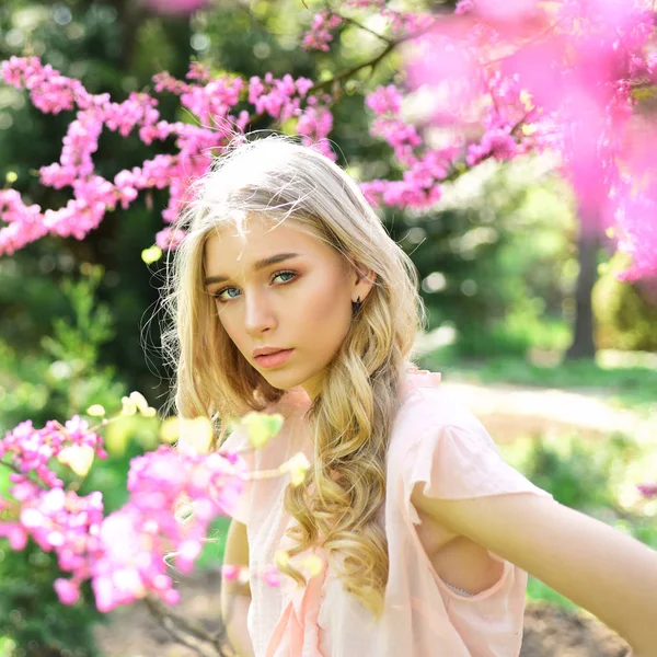 Красивая молодая женщина наслаждается солнечным днем в парке во время сезона цветения вишни в хороший весенний день . — стоковое фото