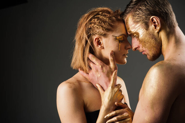 Сексуальная пара с золотым макияжем, копировальное пространство. Эротические игры влюблённых пар. Золотая маска и красота коллагена. 24K Gold. Золотой спа и лечение кожи. Мужские и женские отношения
