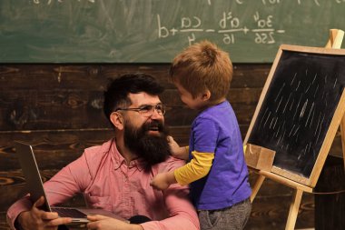 evde eğitim. Gülümseyen baba oğlu yeni becerilerinin öğretimi. Baba ve oğul birbirine sevgiyle bakarak. Oturan babası sarılma çocuk ayakta. Ana sayfa eğitim kavramı