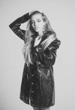 moda aksesuarları. Uzun saçlı kız siyah pelerin, gri arka plan giyer. Kadın şık pelerin veya mackintosh dalgın yüz çekici.