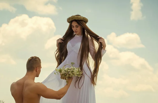 愛の宣言 マッチョ筋肉胴とは 長い髪の女性に花を与えます 曇り空に愛のカップル ロマンス 夏の休暇の概念 — ストック写真