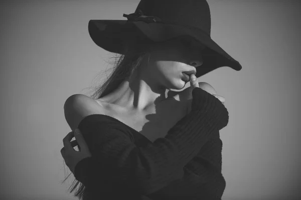 Mulher misteriosa. Retrato de mulher bonita elegante em um vestido preto e chapéu largo no fundo do céu azul — Fotografia de Stock