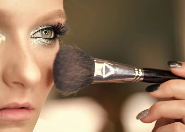 Make-up malam. Gadis muda cantik dengan mata biru berpose dengan tassel untuk menerapkan make-up. Gambar close-up model — Stok Foto