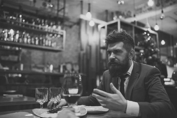 Reunión en el restaurante. Hombre barbudo en el restaurante con compañero. Negocios en marcha y comunicación. El cliente del bar de confianza habla en la cafetería. Fecha o reunión de negocios de hipster en el pub — Foto de Stock