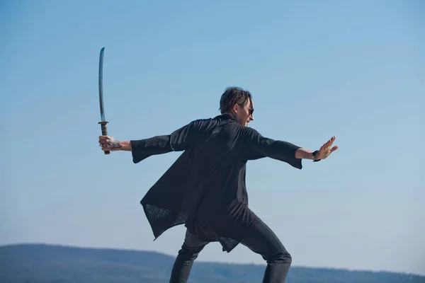 Hombre con espada katana de pie en el cielo azul —  Fotos de Stock