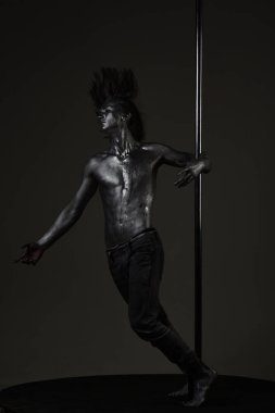 Güçlü dansçı egzersiz kutup. Özgürlük. Pole dans spor. Pilon üzerinde dans gümüş gövde sanat kaslı adam. Metal yüzey ile seksi maço. Atletik adam olun akrobatik öğeleri pilon üzerinde.