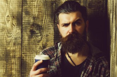 Sabah kahve. Mavi plastik bardak tutan adam kaşlarını