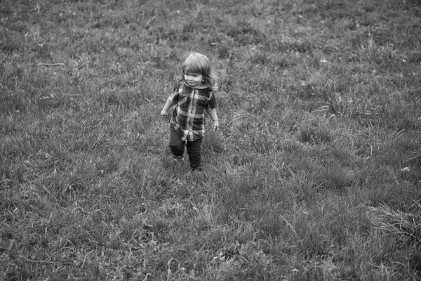 子供は歩きます。緑の芝生の上の小さな男の子 — ストック写真