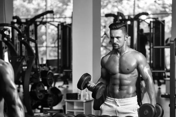 Entrenamiento con pesas. hombre musculoso con mancuerna —  Fotos de Stock