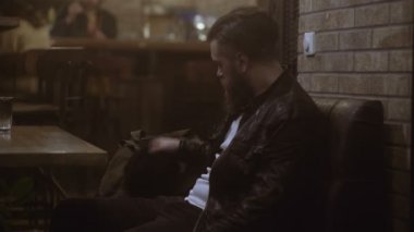 Mutlu genç adam yanında smartphone kafede oturan konuşma