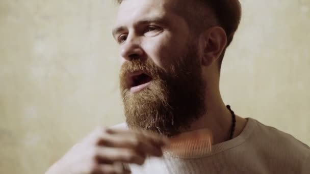 Bonito homem caucasiano pentear barba e sorriso — Vídeo de Stock