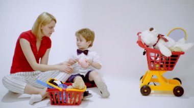 Para tasarrufu. Finansal eğitim. Anne ve oğlu kumbara ile birlikte tam olarak mutluluk anı, finansal eğitim ve etkinlik çocuk aile yaşam için öğrenme kavramı için jeton atın