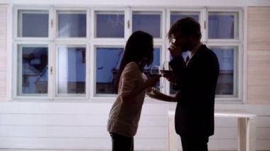 Güzel genç bardak kırmızı şarap ile çift. Genç romantik çift bardak kırmızı şarap ile kutluyor. Romantik Çift kırmızı şarap içme