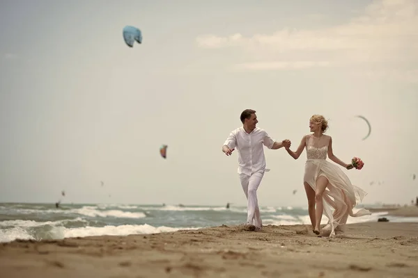 Una pareja encantadora. Correr pareja de boda en la playa — Foto de Stock