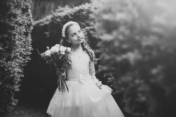 Meisje met bloemen. Mooie kleine bruidsmeisje permanent buitenshuis — Stockfoto