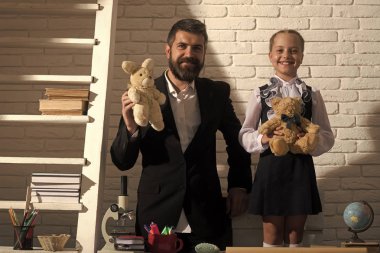 Okula dönüş. Kız ve babası beyaz tuğla zemin üzerine sınıfta