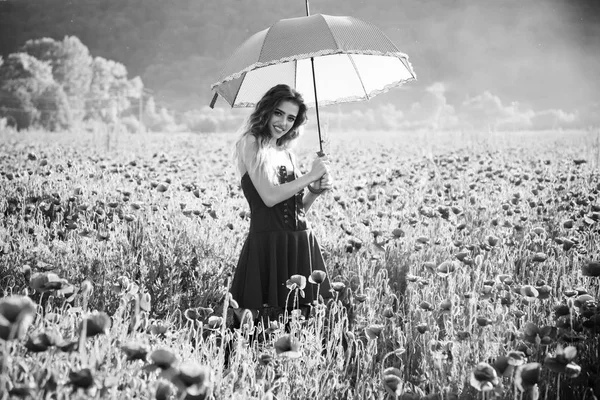 Sommerstimmung. glückliches Mädchen mit dem rosa Regenschirm über rotem Mohnfeld — Stockfoto