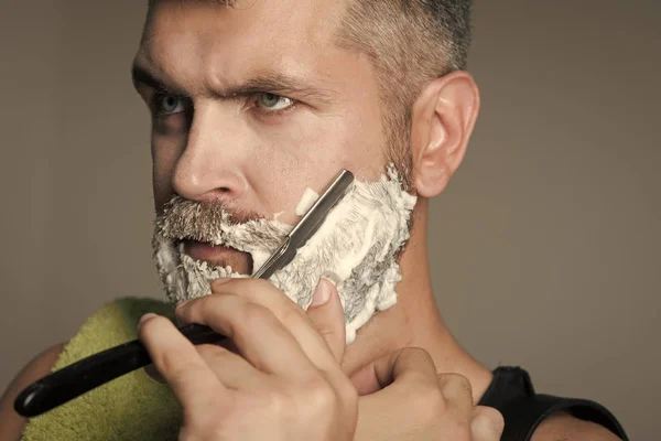 Man skär skägg. Allvarlig hipster i barbershop, ny teknik. — Stockfoto