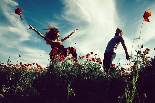 Euphorie. homme et fille dans le champ de pavot rouge — Photo