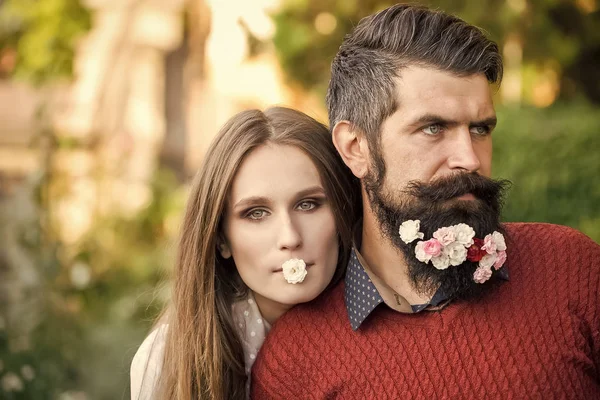 Влюбленная пара. Девушка и мужчина с цветами на бороде — стоковое фото