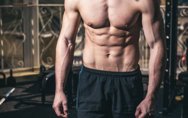 Erkek torso, altı paketleri, arka plan, jimnastik ile kas maço kapatın. Sporcu atlet kaslı çekici görünüyor. Çıplak gövde, kas göğüs ve spor salonunda güçlü silah. Spor ve spor salonu konsept