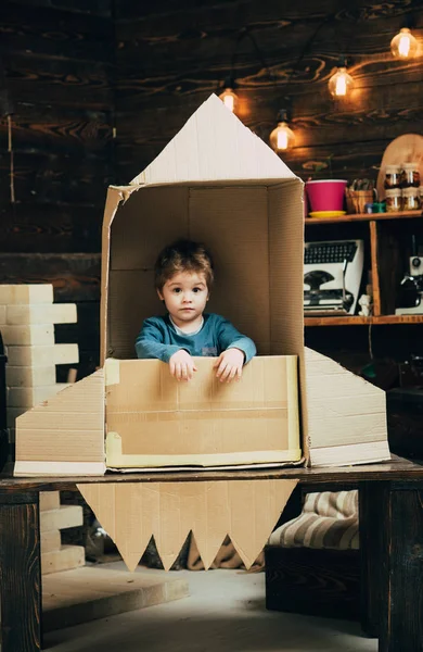 Niño pequeño jugar en cohete de papel, la infancia. Concepto del Día de la Tierra. Educación y desarrollo de ideas para niños. Viaje y aventura. Sueño con la carrera del cosmonauta. Tus sueños pueden hacerse realidad —  Fotos de Stock