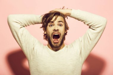 Korkmuş bir adam. uzun uncombed saçlı şaşırmış adam sabah uyanmak