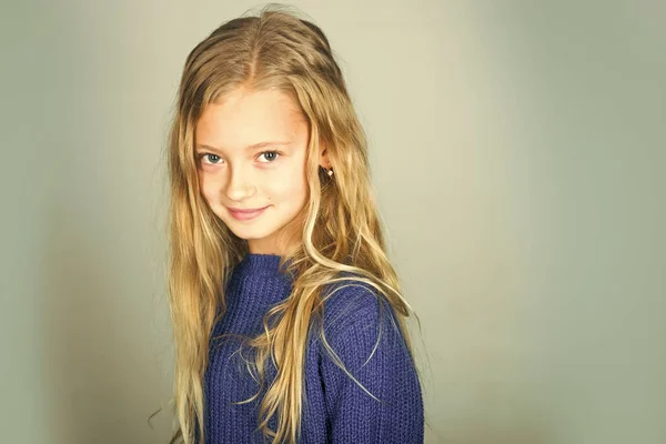 Ropa de bebé. Chica con estilo con cara bonita sobre fondo gris. Belleza, moda infantil y cabello sano. Niña con el pelo largo. Modelo de moda, belleza, mira. Peluquería, cuidado de la piel, estilo casual . —  Fotos de Stock