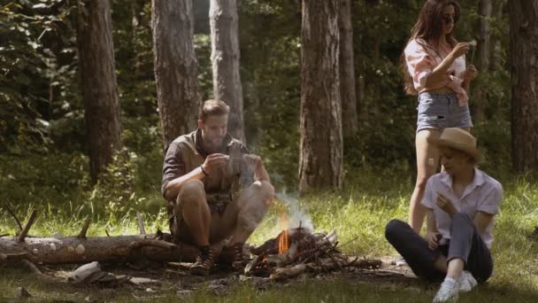 Groep vrienden kamperen. groep vrienden op kampvuur marshmallows roosteren. Vrienden roosteren zoete marshmallow op een brand in de avond in het forest. Gelukkig vrienden genieten van vuur in de natuur — Stockvideo