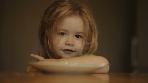 Rapazinho sentado à mesa, a tomar o pequeno-almoço. Alimentação saudável para um bebê — Vídeo de Stock