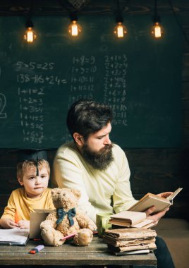 Okuma kavramı. Öğretmen okul çocuğu için kitap okumak. Küçük çocuk adam okuma kitabı sınıfta dinlemek. Okumaya devam edin