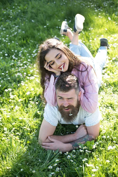 Kadın duman sigara ile daisy ağzına üzerinde yalan söylemeyi. Çift yeşil çimenlerin üzerinde rahatla. Özgür ve rahat hissediyorum. Birlikte olduğum için mutluyum. Yaz tatili keyfini
