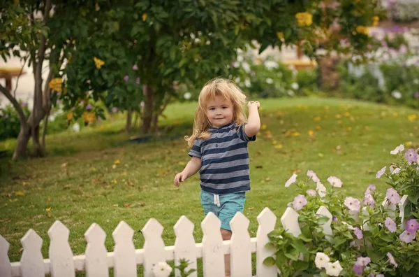 Šťastné dětství. dítě nebo šťastný malý chlapec venkovní poblíž bílý dřevěný plot — Stock fotografie