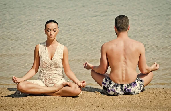 Armonía en la familia. yoga pareja relajante haciendo meditación en la playa —  Fotos de Stock
