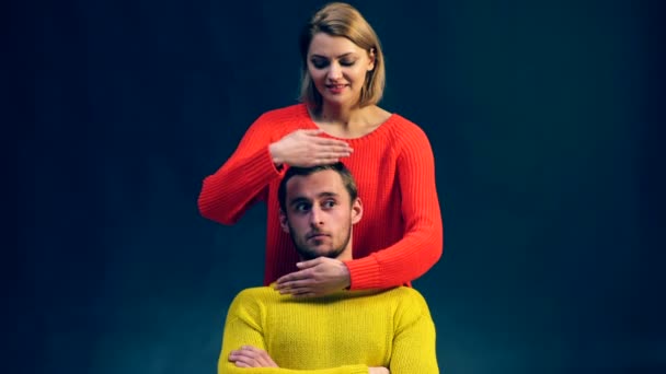Мальчик в жёлтом свитере проявляет множество эмоций после того, как девушка в красном свитере показывает его лицо. Концепция эмоций . — стоковое видео