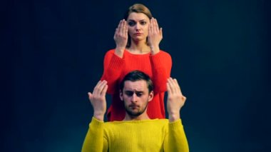 Bir kız ve bir erkek renkli kazak içinde farklı duygular göster. Pandomim siyah arka plan üzerine bırakılan jaws ile hayran.