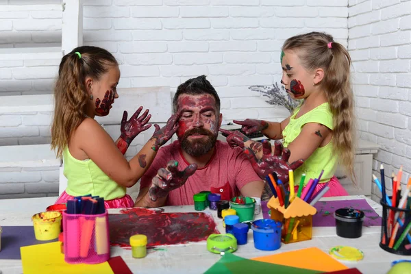 Daughters and dad with painted hands